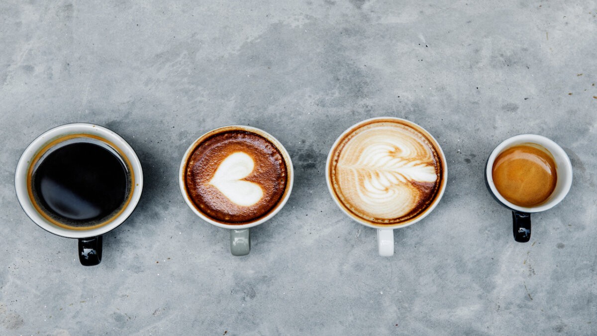 Exploring Different Brewing Four different coffee beverages arranged in a linear composition on a grey surface, showcasing various preparation me...